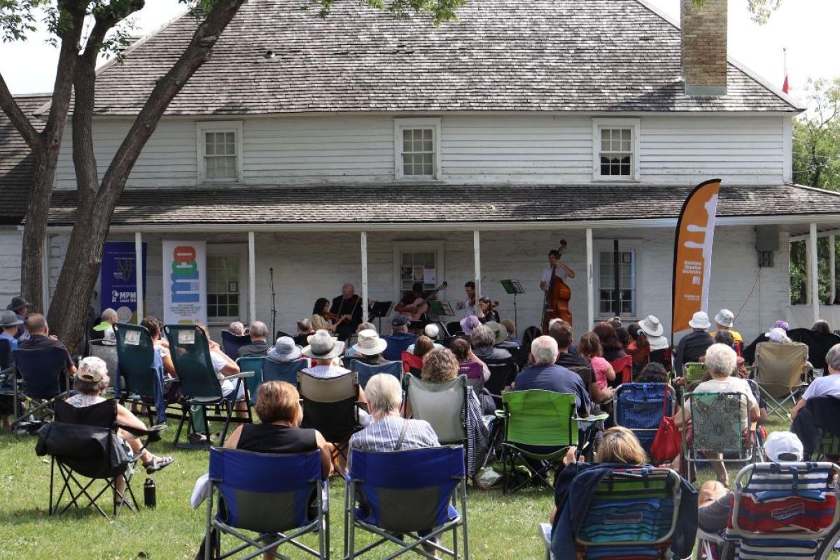 people in lawnchairs watching a concert outdoors